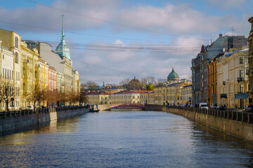 View of the Moika River, the Red Bridge, the dome of the Kazan Cathedral and the tower with the spire of the trading house on a sunny autumn day, St. Petersburg, Russia