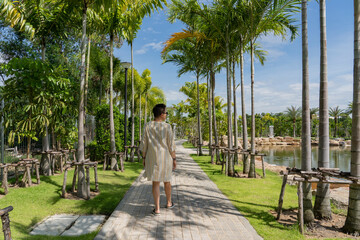 Fototapeta na wymiar A woman walks along a path in a city park. Thailand. Pattaya.