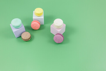 Macaroons on green background. Close up of an background of desserts. Top view 