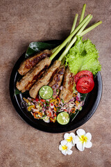 Sate Lilit, traditional Balinese minced seafood or chicken satay with lemongrass as aromatic skewer, served with sambal matah.