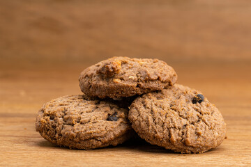 Delicious homemade chocolate chip butter cookies piled on wooden table.