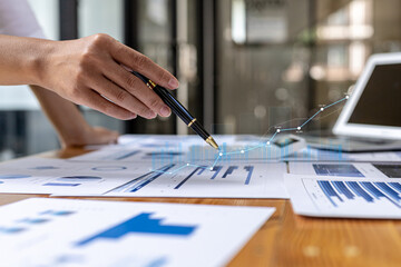 A business man examines data on financial documents, company financial reports, graphics showing financial and numerical growth data. The concept of financial management to grow and be profitable.