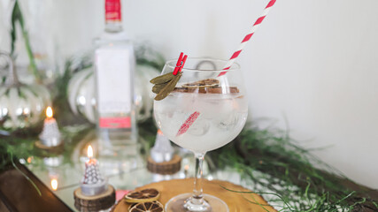 Cóctel alcohólico de fiestas ginebra con hielo, hecho en casa, fondo decorado, enfoque selectivo, botella visible al fondo