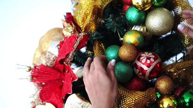Latin Woman decorates tree for christmas