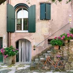 Fototapeta na wymiar Mediterranean house with flowers, outside stairs, and vintage bicycle