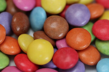 Fototapeta na wymiar Close-up macro shot of colourful sugar coated chocolate candy sweets, background, texture