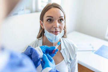Doctor/nurse taking PCR nasal swab test from a pregnant woman. COVID-19 vaccination concept.