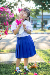 PHRAE, THAILAND – NOVEMBER 20: Asian girl in kindergarten uniforms is happy outside the building on the December 20,2021 in PHRAE,TH.