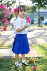 PHRAE, THAILAND – NOVEMBER 20: Asian girl in kindergarten uniforms is happy outside the building on the December 20,2021 in PHRAE,TH.