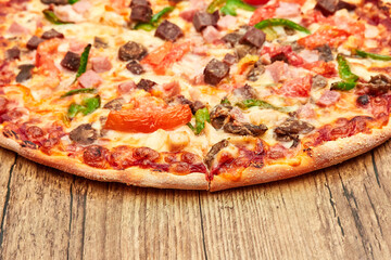 Italian pizza with meat, close-up on a wooden table top