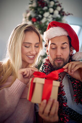 Obraz na płótnie Canvas Happy caucasian couple exchanging Christmas gifts