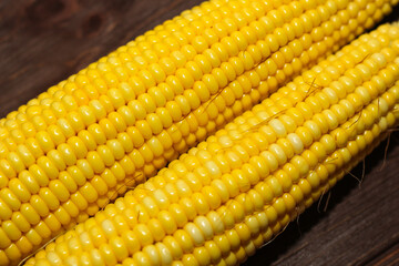 Sweet yellow corn lies on a wooden table.