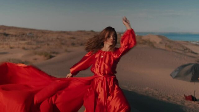 An Asian Woman In A Red Dress Dancing On Sand Dunes