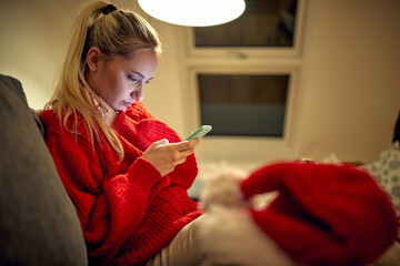  woman text messaging on  smartphones on Christmas