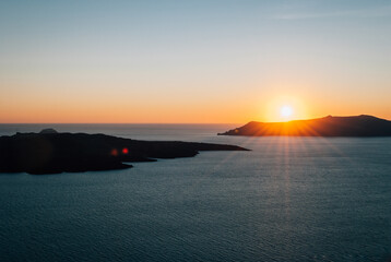 View of the setting sun over the volcano, caldera, Santorini, Greece