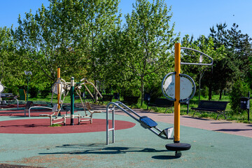 Outdoors fitness device machine in a city park for sport and activities, in Bucharest, Romania, in a sunny summer day.