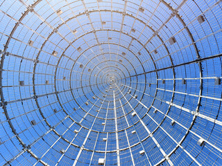 View from below of metal structure of christmas tree by day.