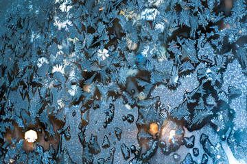 Frosty patterns on the window pane at night. Close-up	