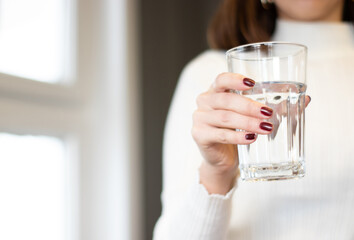 water glass standing in woman's hand