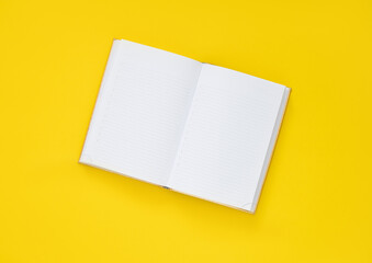 notebook with pencil on a yellow background