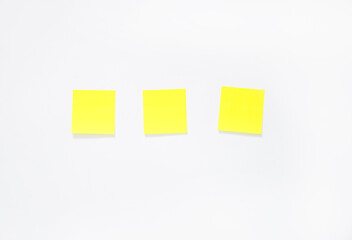three yellow sticky notes on a white background