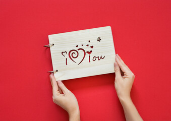 person holding a board with a message "I love you"  on a red background. Copy space
