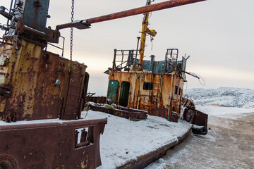 Remains of an old fishing boat, old nets and ropes on the Arctic Ocean beach. The village of Teriberka.