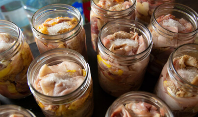 Raw chicken and duck pieces for stew in glass jars. The jars are prepared for autoclaving. - obrazy, fototapety, plakaty