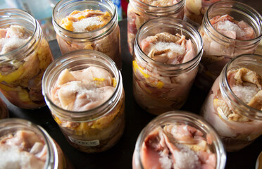 Raw chicken and duck pieces for stew in glass jars. The jars are prepared for autoclaving.