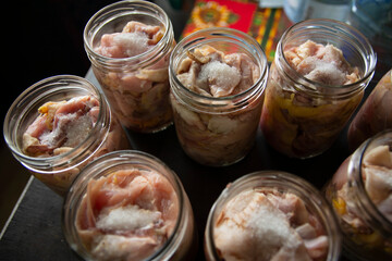 Raw chicken and duck pieces for stew in glass jars. The jars are prepared for autoclaving.