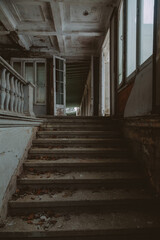 Fototapeta premium An ancient staircase in an old abandoned manor. Dirty shabby steps. Beautiful architecture.