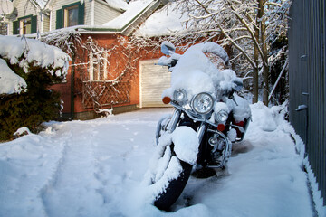 Motorcycle under the snow on winter parking