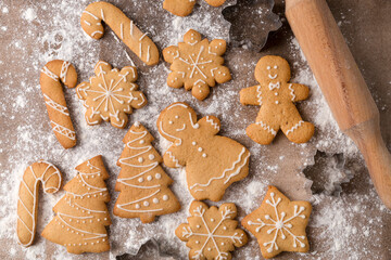 Christmas sweet food. Homemade gingerbread cookies and kitchen utensils on brown table.