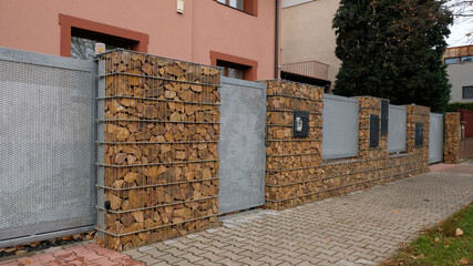 Gabion retaining wall - brown stones in gabion metallic baskets kept by retaining wall. Modern...