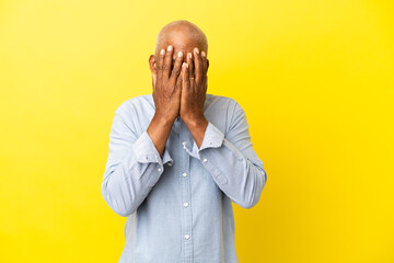 Cuban Senior isolated on yellow background covering eyes by hands