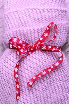 Christmas backgound, Warm wool knitted scarf  with the red ribbon. Concept of Christmas gifts with love