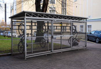 Bicycles in a cage on the street. Special garage-cage for bicycles. Bicycle storage device