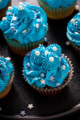 Unique cupcakes with white sprinkles and blue cream.