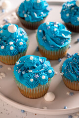 Tasty cupcakes with flower shaped blue cream.