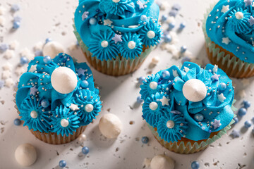 Tasty cupcakes made of sprinkles and blue cream.