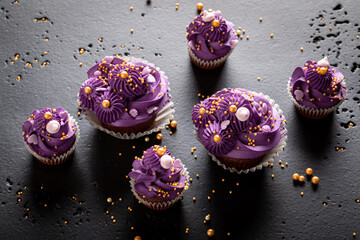 Beautiful cupcakes with flower shaped purple cream.