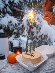 Hello winter, cozy winter mood. A beautiful winter picnic with tea in a thermos and a bento cake...