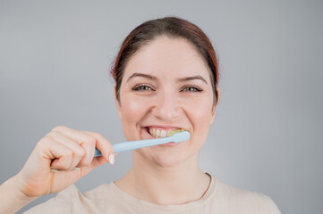 Close-up portrait of caucasian woman brushing her teeth. The girl performs the morning oral hygiene procedure