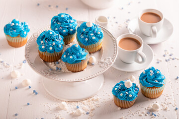 Sweet blue cupcakes with flower shaped cream.