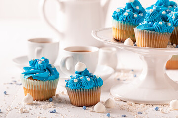 Beautiful blue cupcakes served with coffee in white porcelain.