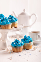 Beautiful blue cupcakes made of white sprinkles and cream.