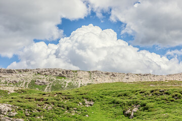 Fototapeta na wymiar A beautiful landscape of an alpine plateau and cumulus clouds above it. Italian Dolites