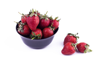 Fresh strawberry in black ceramic bowl on white background.