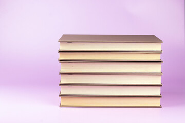 Stack of books on pink background. Study, education and back to school concept.