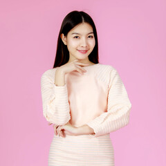 Portrait studio shot of Asian young happy beautiful pretty long black hair female teenager model in casual sweater outfit standing look at camera on pink background